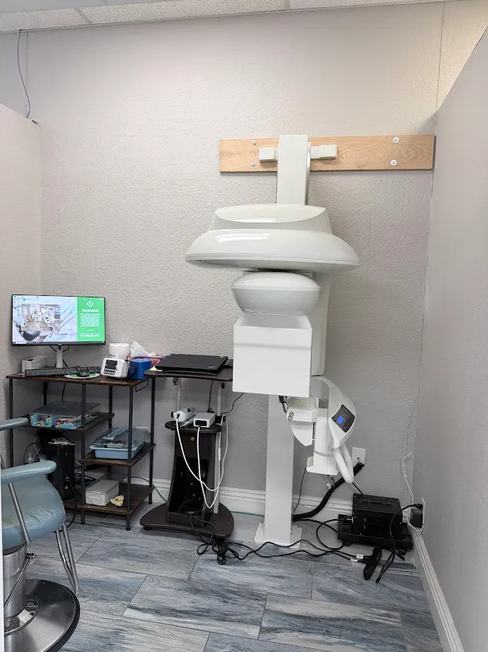 Dental imaging equipment in a modern dental clinic, highlighting advanced technology for precise implant procedures, with a monitor displaying patient information and a clean, organized workspace.