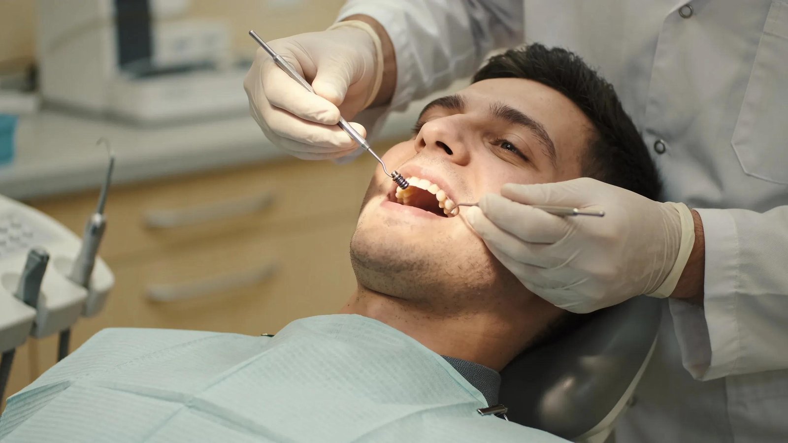 Dentist examining patient's mouth during dental implant removal procedure.