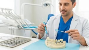 Dental professional examining dental implant model and tools