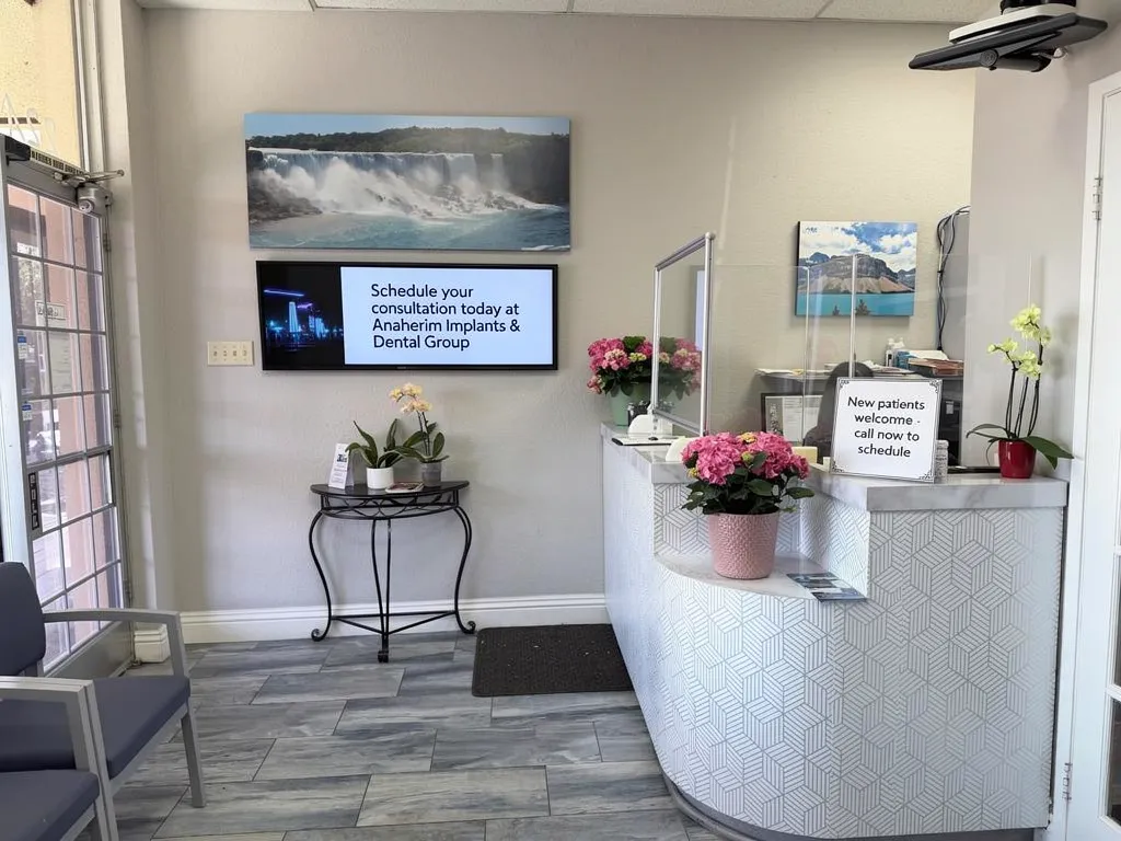 Anaheim Implants & Dental Group reception area with welcome display and floral arrangements.