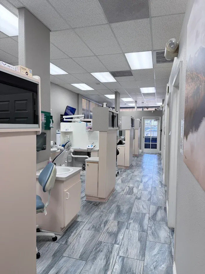 Dental clinic hallway with multiple treatment bays, dental chairs, and equipment