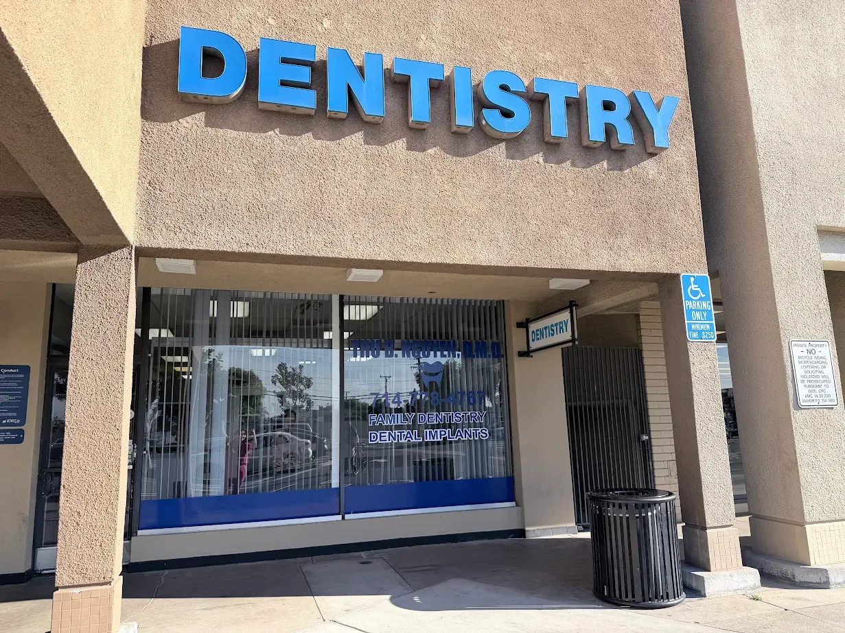 Exterior of a dentistry office with a large blue "DENTISTRY" sign and handicap parking